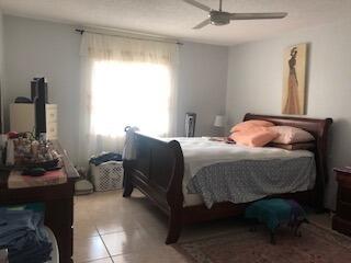 bedroom with light tile flooring and ceiling fan