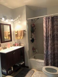 full bathroom with shower / bath combination with curtain, toilet, vanity, and tile flooring