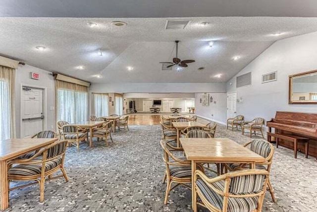 dining area featuring lofted ceiling, a textured ceiling, and ceiling fan