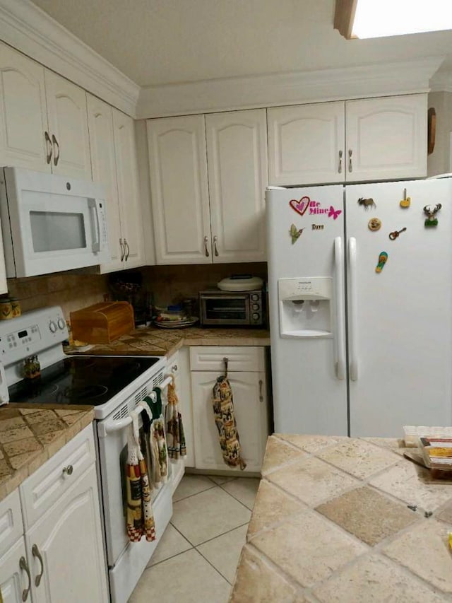 kitchen featuring light tile flooring, white appliances, white cabinetry, backsplash, and tile counters