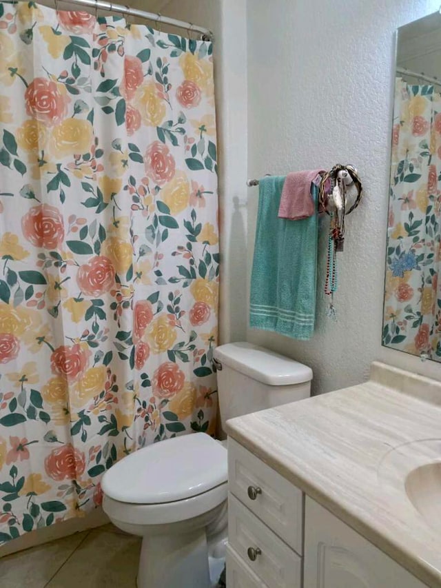 bathroom featuring toilet, tile floors, and oversized vanity