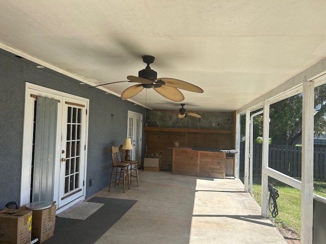 sunroom featuring plenty of natural light, ceiling fan, and french doors