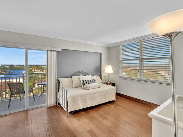 bedroom with hardwood / wood-style flooring, multiple windows, and access to outside