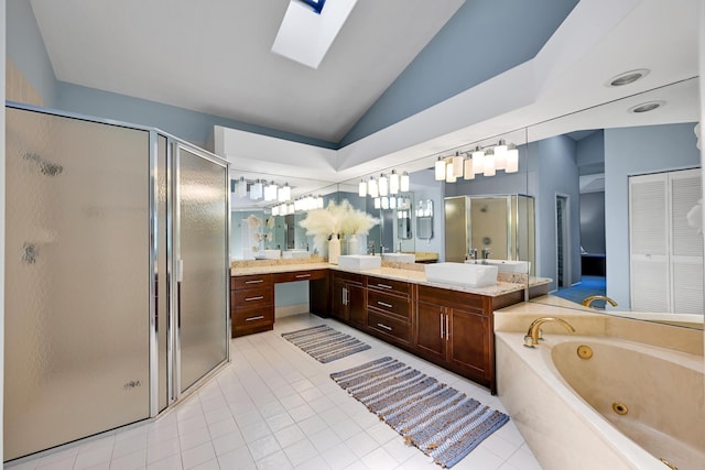 bathroom with vaulted ceiling with skylight, a jetted tub, tile patterned flooring, a shower stall, and vanity