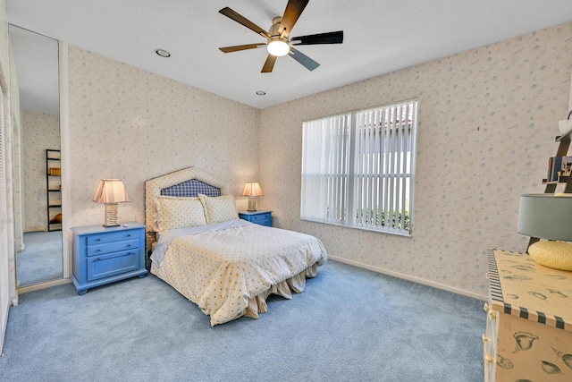 bedroom with carpet floors, wallpapered walls, baseboards, and ceiling fan