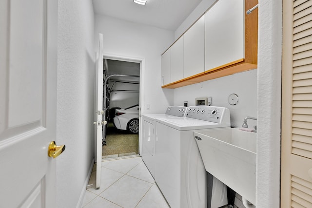 laundry room with cabinet space, separate washer and dryer, light tile patterned flooring, and a sink