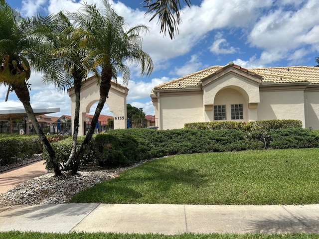 6090 Evian Pl, Boynton Beach, FL 33437 - view of side of home with a tiled roof, a yard, and stucco siding