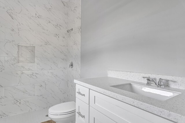 bathroom featuring vanity, toilet, and walk in shower