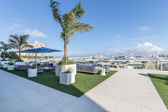 view of property's community featuring a dock, a water view, and a lawn