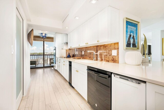 kitchen with sink, backsplash, black dishwasher, white dishwasher, and white cabinetry