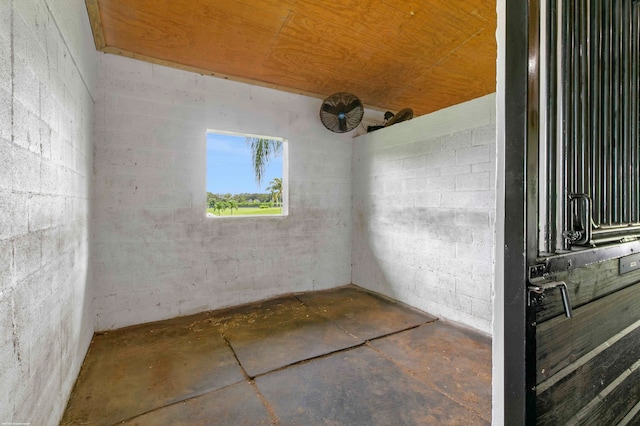 spare room featuring concrete floors and wooden ceiling