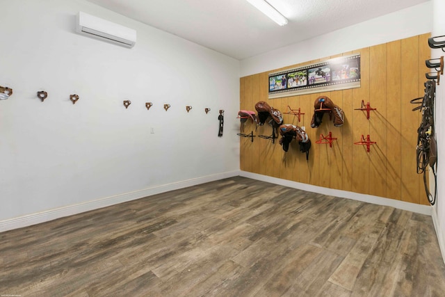 interior space with wood walls, dark hardwood / wood-style floors, and a wall unit AC