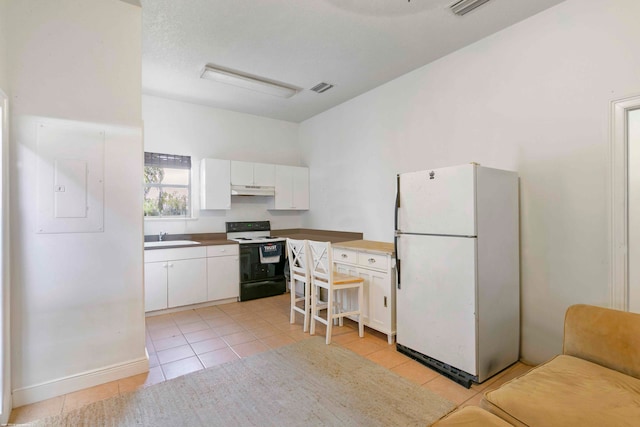 kitchen with white cabinets, light tile floors, white appliances, and sink