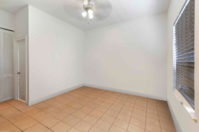 empty room with light tile flooring and ceiling fan