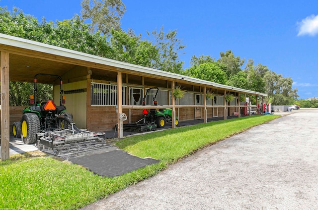 view of stable featuring a yard