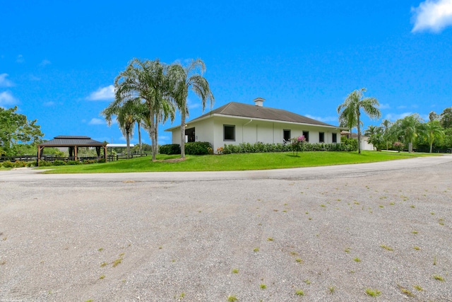 single story home with a gazebo and a front yard