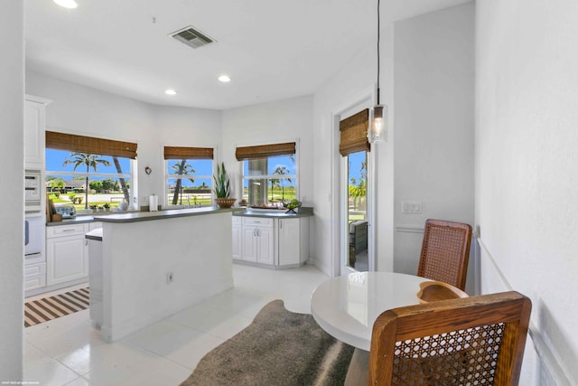 kitchen with light tile flooring and white cabinetry