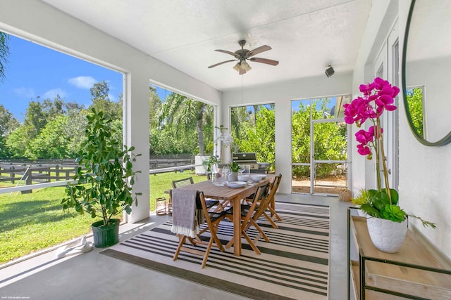 sunroom / solarium featuring ceiling fan