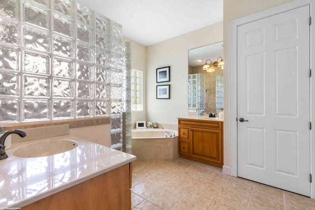 bathroom featuring a chandelier, tiled tub, tile flooring, and vanity