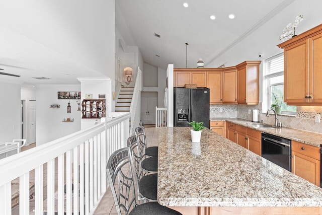 kitchen with sink, decorative backsplash, black appliances, and a kitchen island