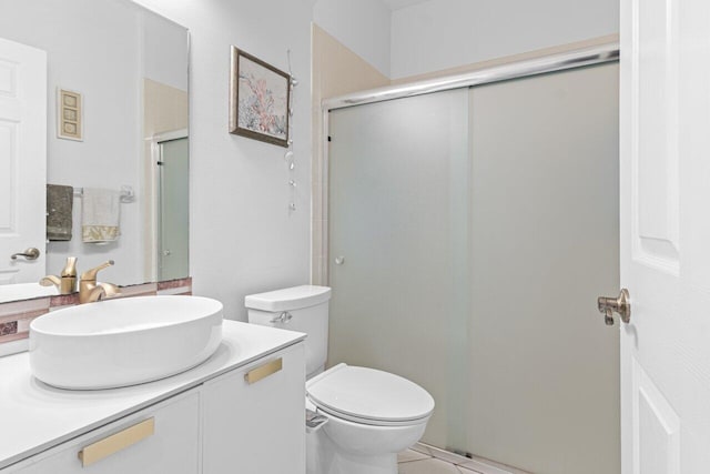 bathroom with tile patterned flooring, toilet, vanity, and a shower with shower door