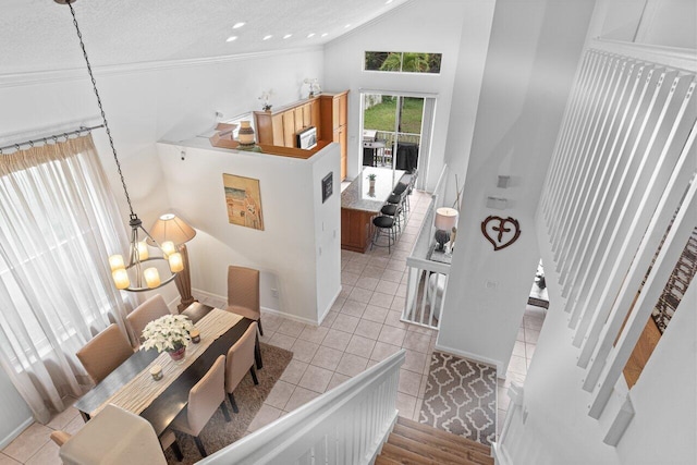 entrance foyer featuring an inviting chandelier, light tile patterned floors, high vaulted ceiling, and a textured ceiling