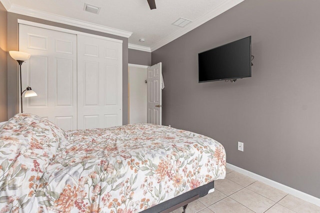 tiled bedroom featuring crown molding, ceiling fan, and a closet