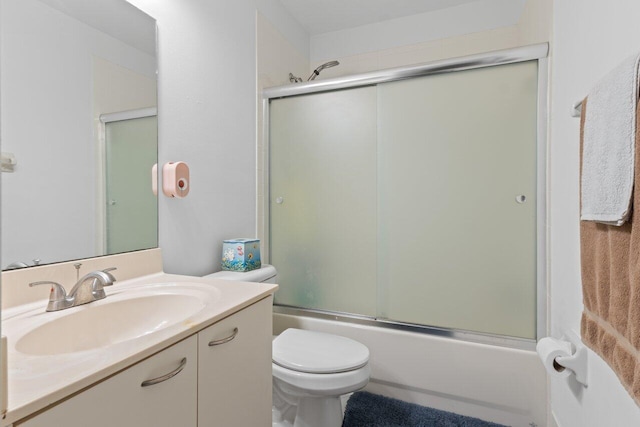 full bathroom featuring vanity, toilet, and combined bath / shower with glass door