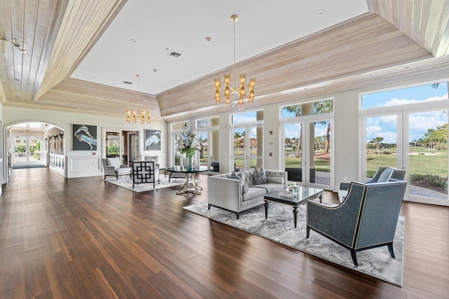 living room with hardwood / wood-style flooring, a tray ceiling, wooden ceiling, an inviting chandelier, and french doors