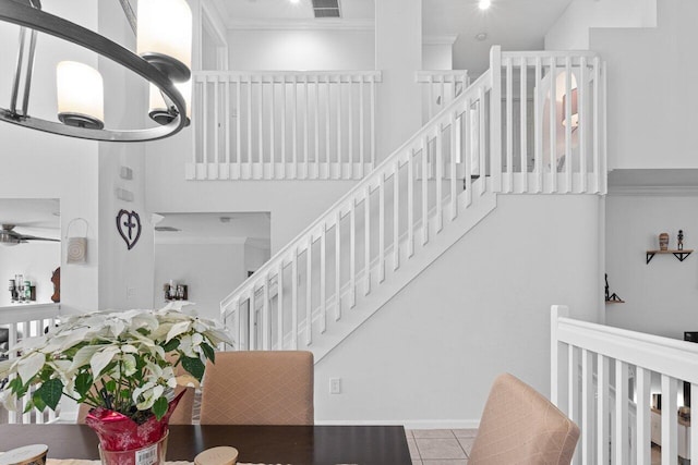 stairs featuring tile patterned flooring, ornamental molding, and ceiling fan