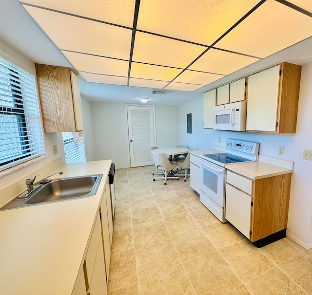 kitchen with white appliances, sink, a wealth of natural light, and light tile floors