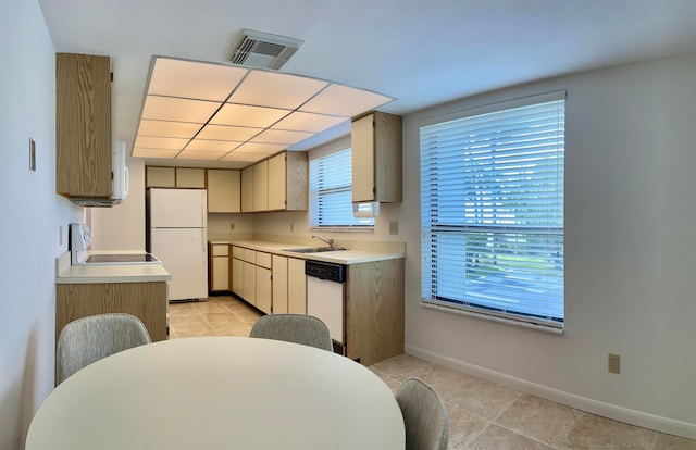 kitchen with light tile floors, dishwashing machine, range, and white refrigerator