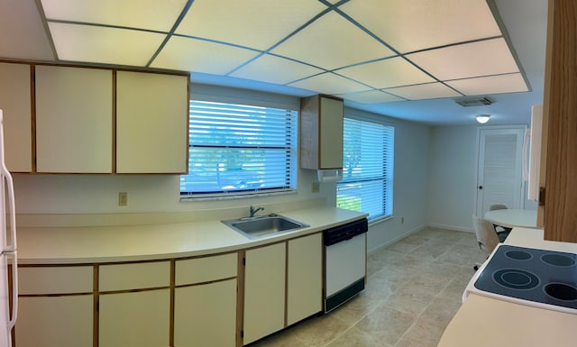 kitchen featuring white appliances, cream cabinets, sink, and light tile floors