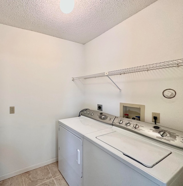 clothes washing area with washer hookup, hookup for an electric dryer, independent washer and dryer, light tile flooring, and a textured ceiling