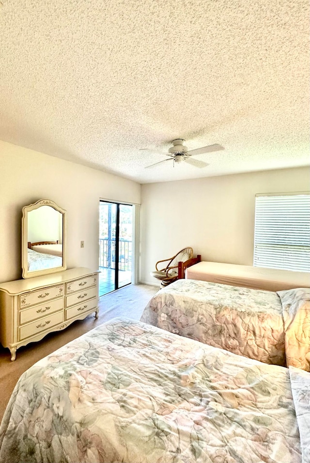 bedroom featuring a textured ceiling, ceiling fan, and light colored carpet