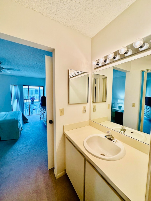 bathroom featuring a textured ceiling, oversized vanity, and ceiling fan