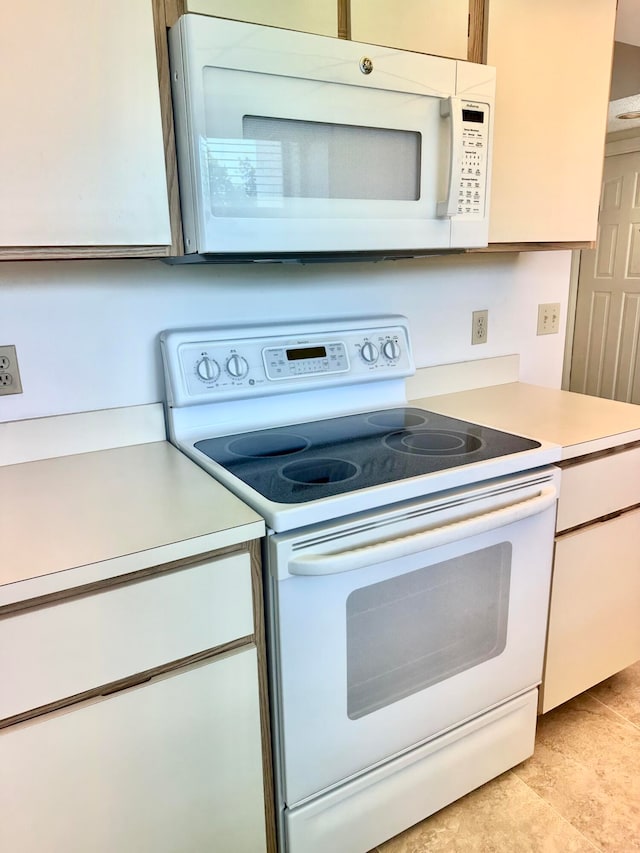 kitchen featuring white appliances and light tile floors