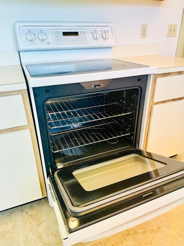 interior details featuring stove and light tile floors