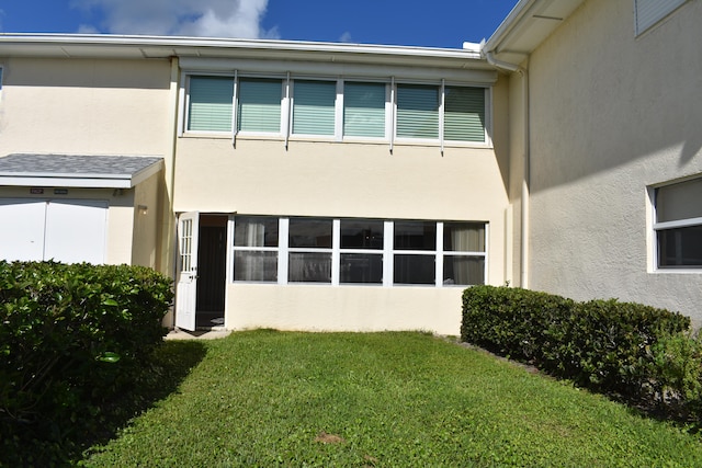 back of house with a lawn