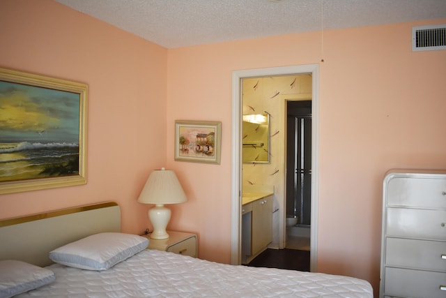 bedroom featuring a textured ceiling and ensuite bathroom