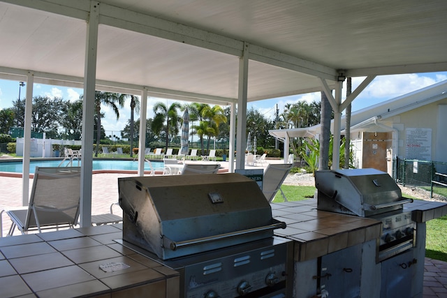 view of patio with a grill, exterior kitchen, and a community pool