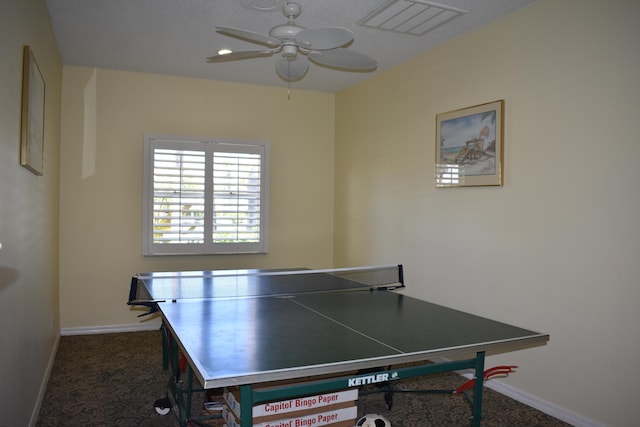 recreation room featuring dark colored carpet and ceiling fan