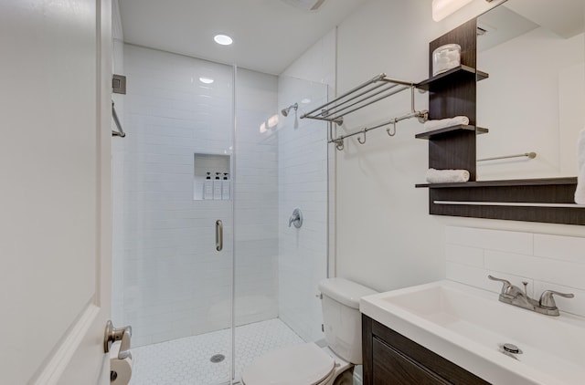 bathroom featuring walk in shower, toilet, vanity, and tasteful backsplash