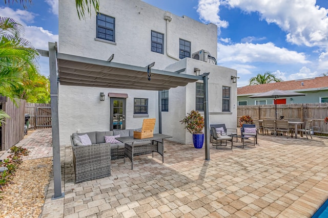 back of property featuring a patio and an outdoor living space