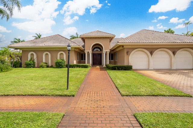 mediterranean / spanish house featuring a front lawn and a garage