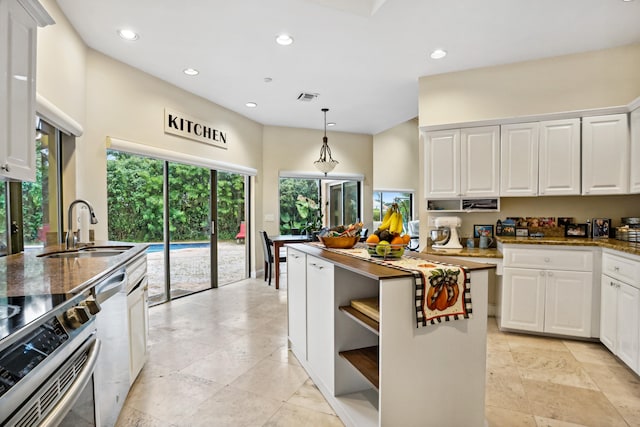 kitchen featuring range, hanging light fixtures, sink, light tile floors, and white cabinets