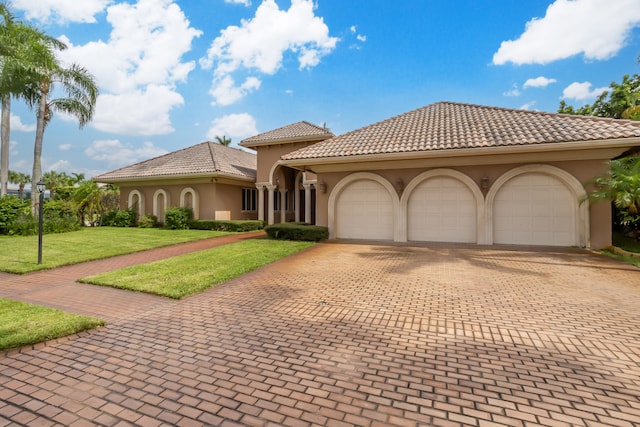 mediterranean / spanish-style home with a front lawn and a garage