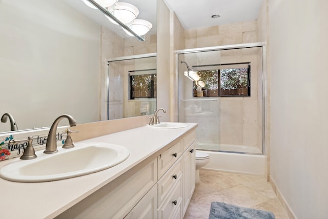 full bathroom featuring double vanity, toilet, shower / bath combination with glass door, and tile flooring