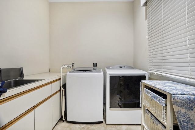 washroom featuring washing machine and dryer and cabinets