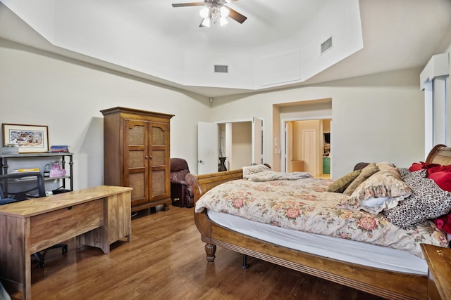 bedroom featuring a raised ceiling, hardwood / wood-style floors, and ceiling fan